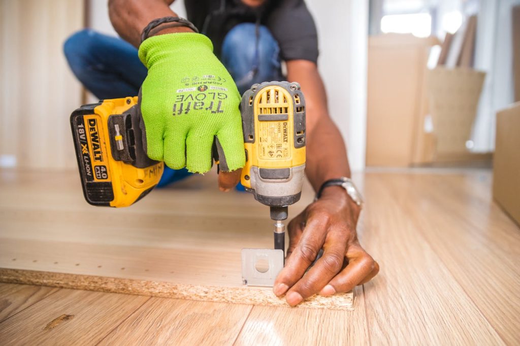 The Art of Drawing Readers In: Your attractive post title goes here Man using a power drill for home improvement on a wooden floor with precision.